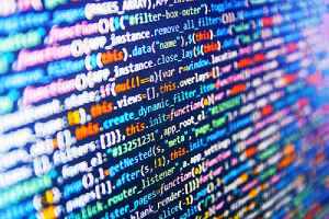 Custom Software developer programming code on computer monitor