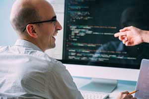 Custom software developer talking to another coder