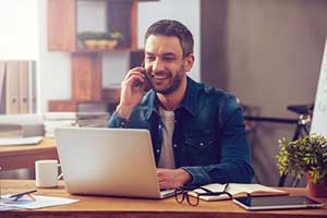Business owner speaking to a client while using his custom CRM software