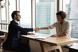 employer shaking hands with database migration company employee