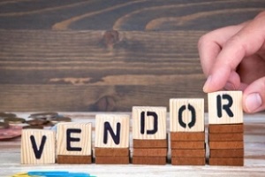 man placing wooden cubes with vendor word on them