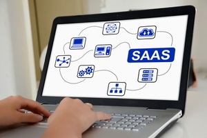 hands on a laptop with screen showing saas concept