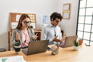 Two employees talking with offshore developers over a video call