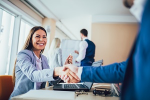 business handshake after closing a deal after an analytics report