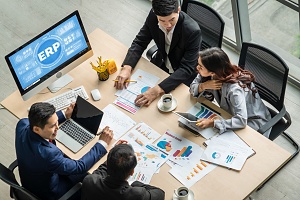 four professionals looking at data using their enterprises resource planning software