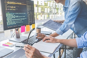 software developers looking through the code of their custom wms system