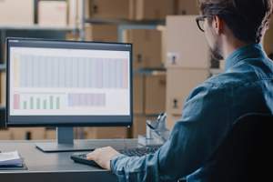 warehouse inventory manager reviewing spreadsheets