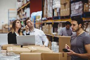 warehouse workers reviewing their cargo hold over several boxes