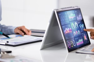 data analyst looking through performance metrics on their laptop