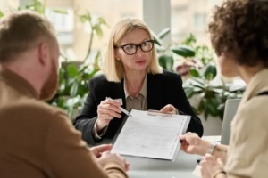 estate agent offring contract papers to the clients