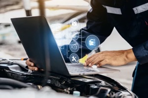 mechanic using laptop checking up on car engines parts for fixing and repair
