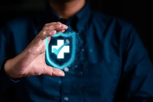 businessman hand holding virtual medical health care symbol