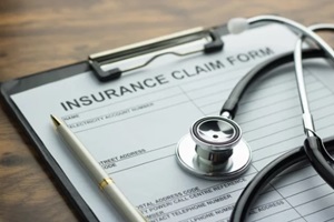 health insurance claim form with stethoscope on wood table selective focus