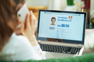 woman at home using cell phone and checking healthcare claims management software