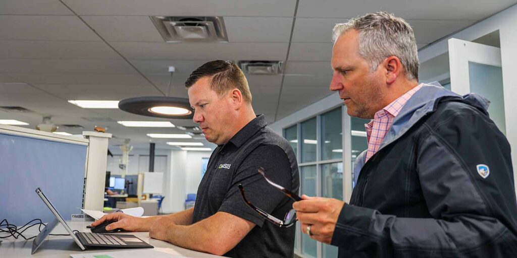 two data professionals reviewing data systems